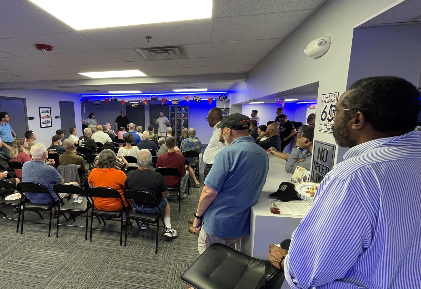 Members seated and standing during the PCA meeting