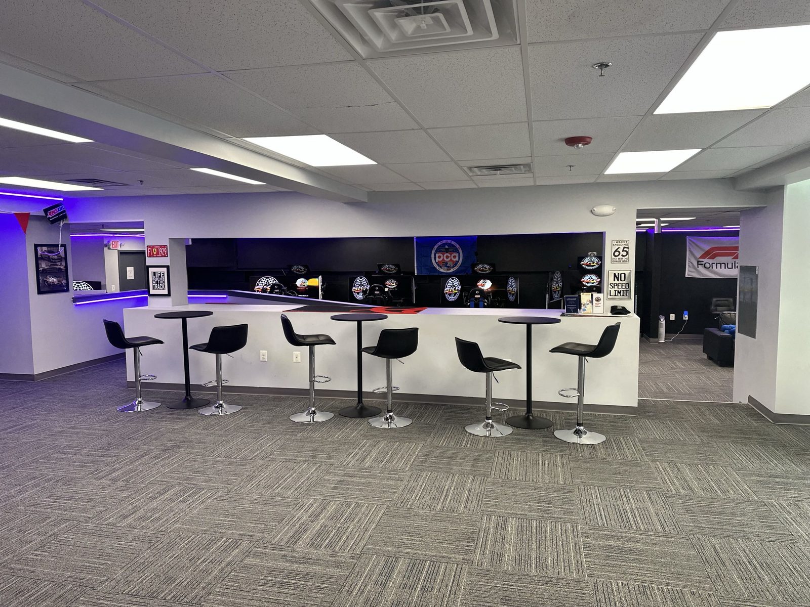 Bar counter with bar stools, sim rigs in the background