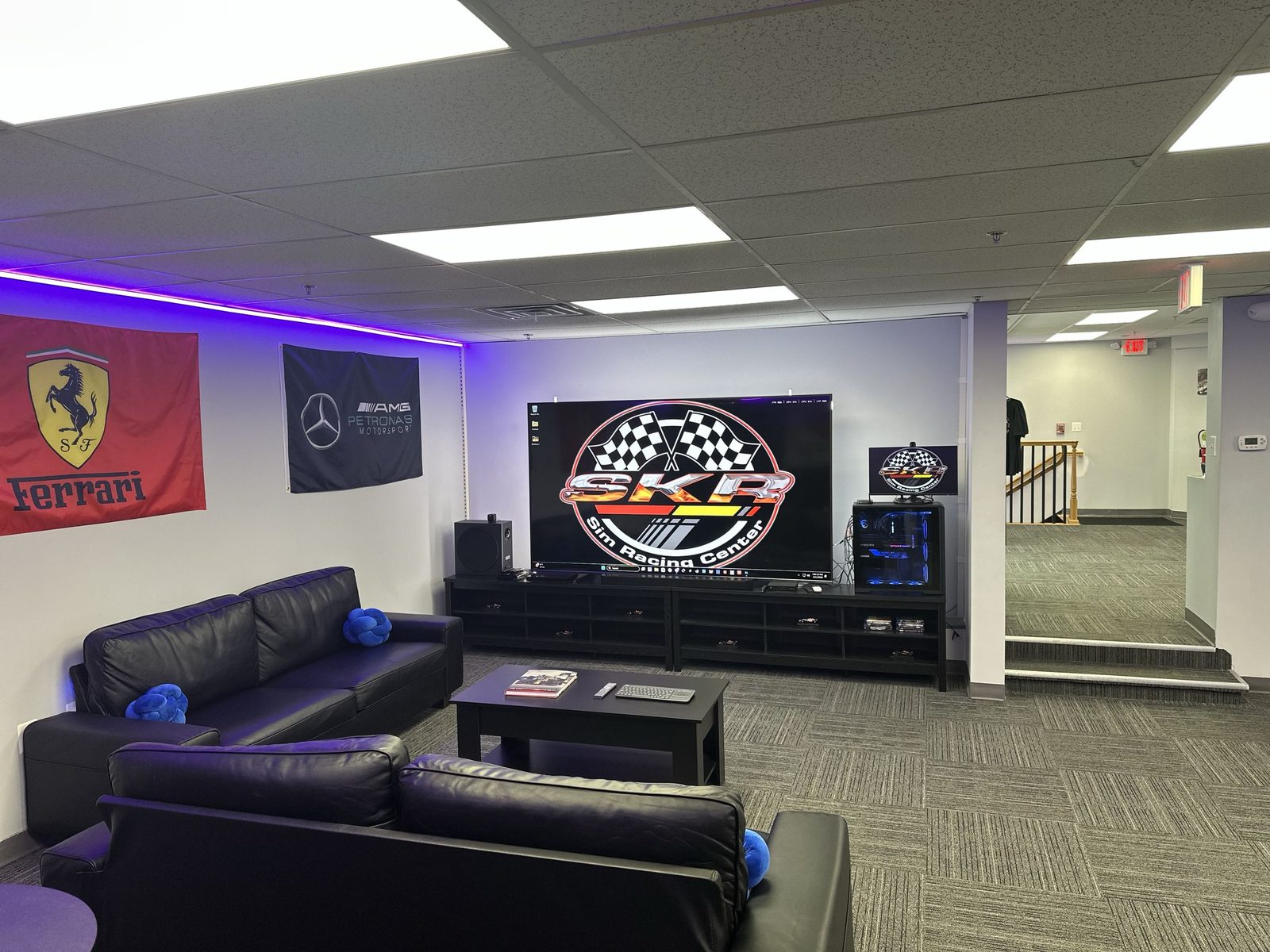 Theater room with large TV displaying SKR logo and seating